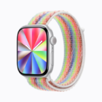 Apple Watch with a rainbow woven nylon strap and a matching radial colour watch face on a white background. Pride.