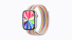 Apple Watch with a rainbow woven nylon strap and a matching radial colour watch face on a white background. Pride.