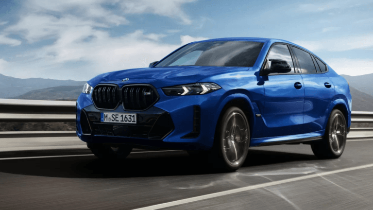 The imported V8 coupe built for urban expressways 4 A blue BMW X6 M60i xDrive moving on an open road, showing its black front grille and coupe stance for the India launch.