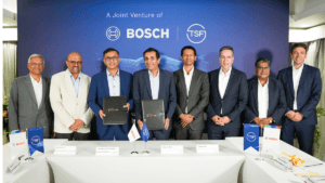 Executives holding signed folders in front of a Bosch and TSF Joint Venture backdrop during a commercial vehicle launch ev...