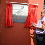 An official pulls a cord to unveil a plaque at the DRDO CBRN field training centre in Delhi as others clap.