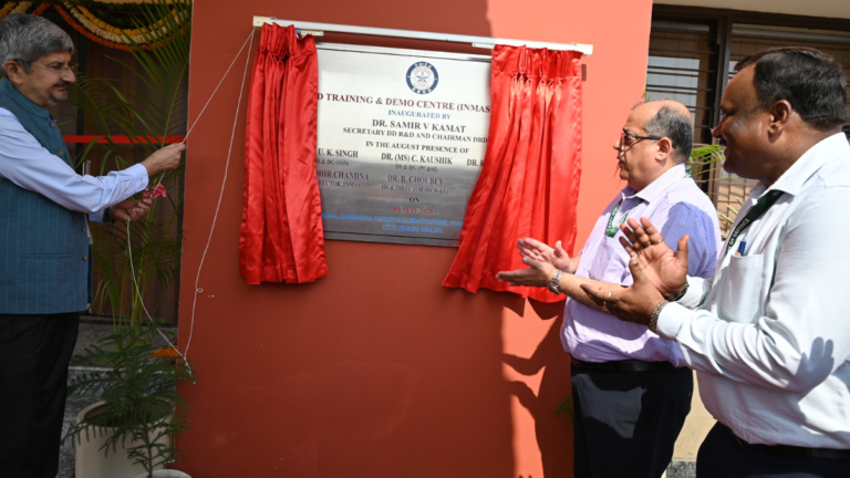 An official pulls a cord to unveil a plaque at the DRDO CBRN field training centre in Delhi as others clap.