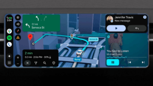 Car dashboard showing 3D buildings on a map next to a music player and message notification navigation.