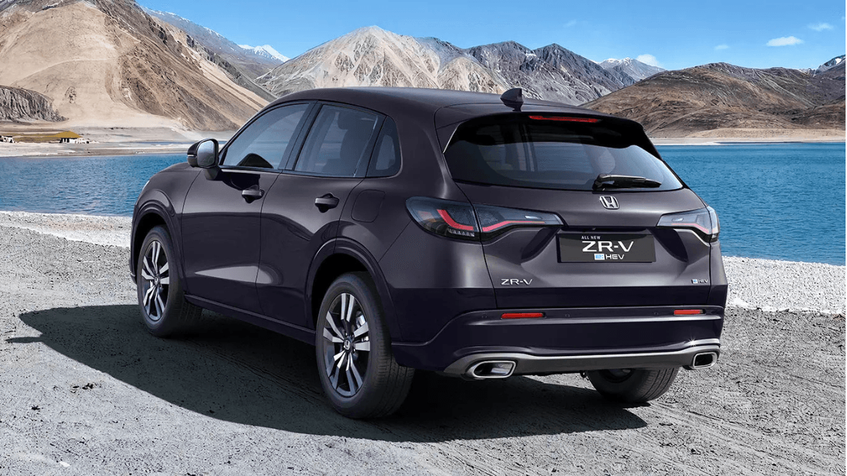 The flagship hybrid SUV designed to challenge European dominance 2 Rear three-quarter view of a purple Honda ZR-V e:HEV crossover showing dual exhaust tips and LED taillights by a lake in India.