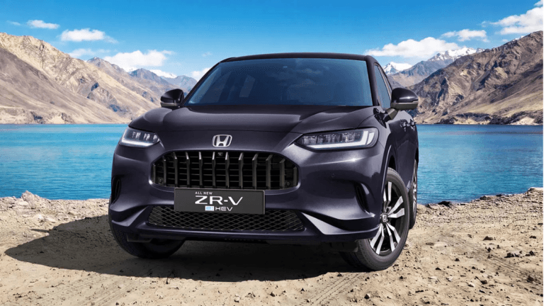 A deep purple Honda ZR-V hybrid SUV parked by a blue lake with Himalayan mountains in the background during its India prev...
