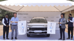 Officials flagging off a white Hyundai vehicle under a tent during the Adhikaar Connect project launch in Pune.