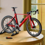 Red LEGO Icons Road Bike on a black display stand over a wooden table with functional drivetrain details