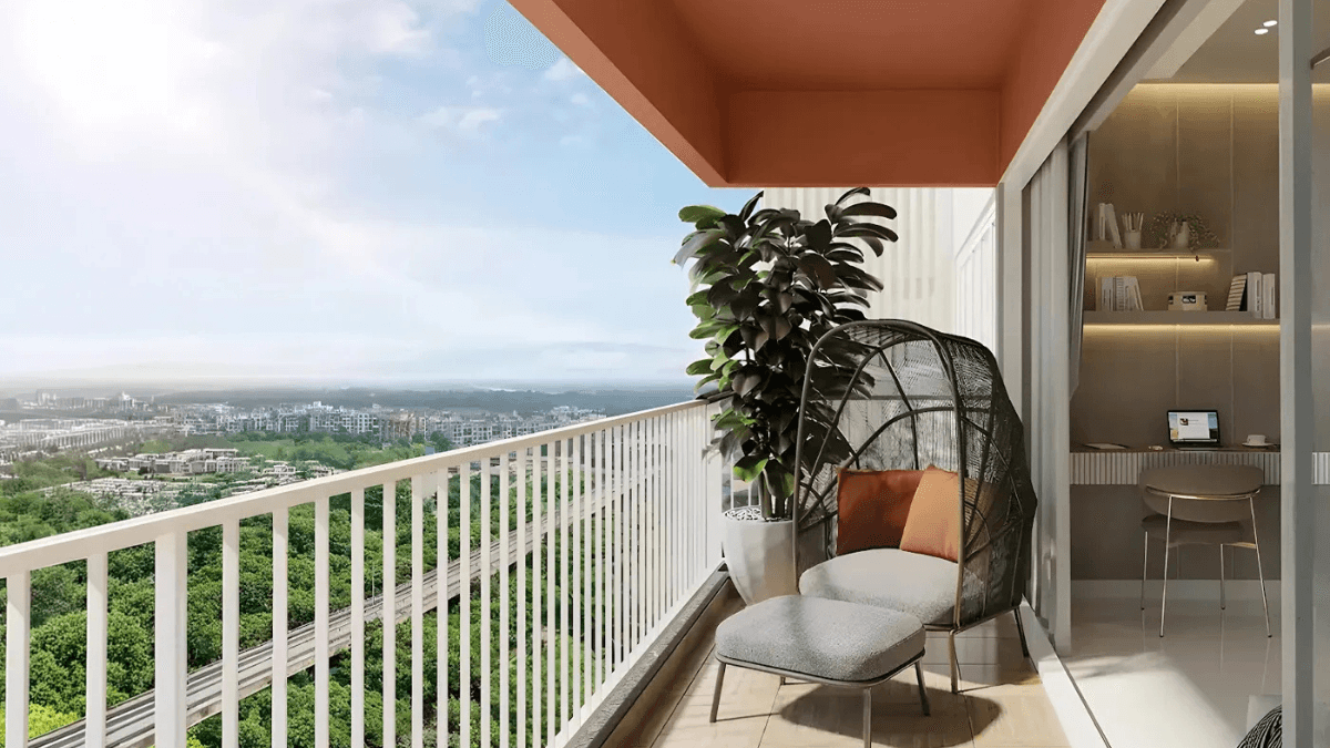 At ₹1.09 crore, this new phase cuts the daily Pune commute 2 An apartment balcony with a modern armchair and footrest overlooking a green landscape and metro line at Mahindra Citadel Pune.