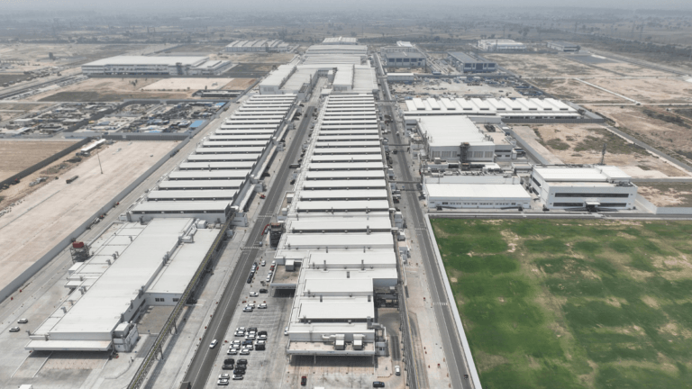 Aerial view of the massive white industrial buildings and parking lots at the Maruti Suzuki Kharkhoda manufacturing facili...