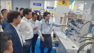 A man explaining a pneumatic training panel to a group of officials at the new Maruti Suzuki manufacturing lab in India.