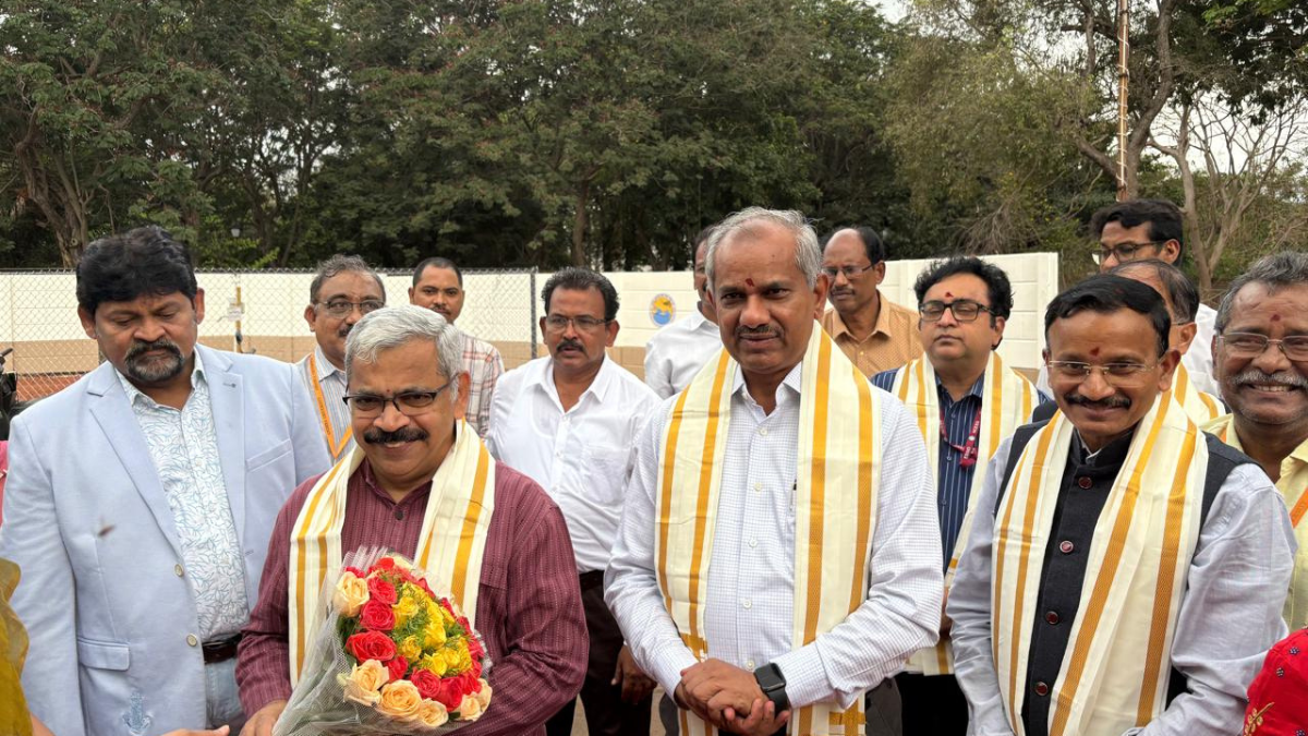 The coastal lab tracking India’s monsoon in real time 2 Dignitaries in ceremonial shawls, one holding a bouquet of roses, standing outdoors at the Vizag research site.
