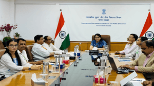 Government officials seated at a conference table with Indian flags during the NeSDA 2025 portal launch meeting at DARPG.