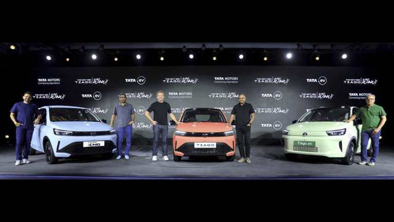 Full stage view with 5 people and 3 Next Gen Tata Tiago cars (iCNG, Petrol, EV) at an India launch event.
