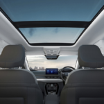 Rear seat view of Tata Nexon interior with voice-assisted panoramic sunroof under a city sky in India