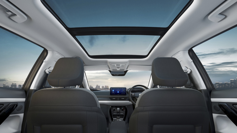 Rear seat view of Tata Nexon interior with voice-assisted panoramic sunroof under a city sky in India