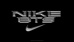 Metallic silver 3D text spelling NIKE above BTS with a swoosh on a black background, marking the new collaboration.