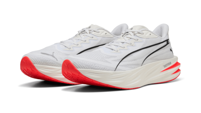 Pair of white Puma Deviate Pure NITRO running shoes with black stripes and bright pink soles designed for tempo training.