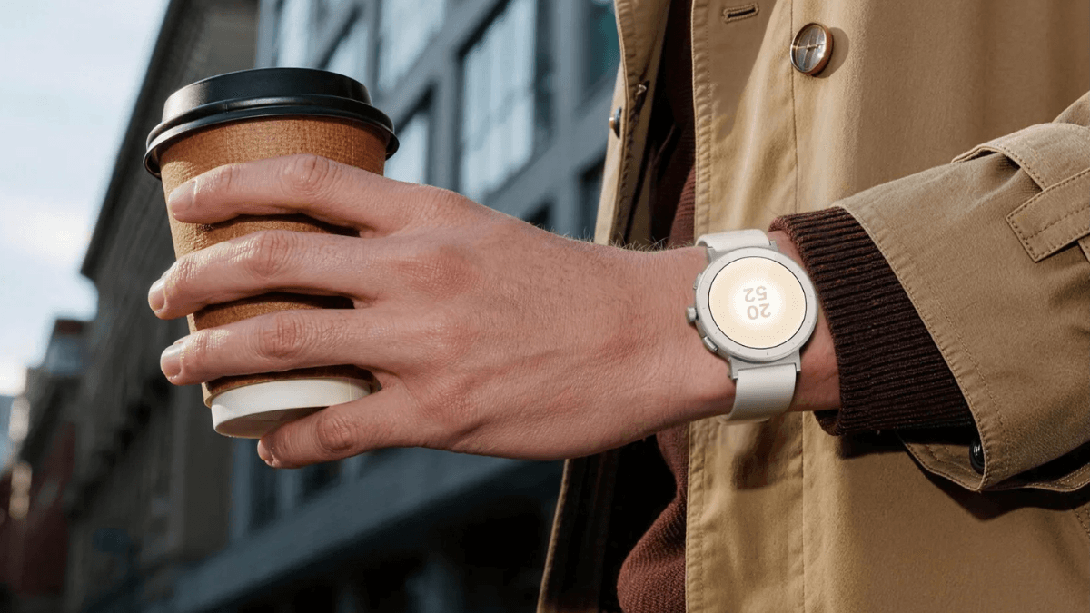 The standalone GPS smartwatch built for phone-free workouts 1 Realme Watch S5 in Sand White worn on a wrist holding a coffee cup outdoors, showing the round AMOLED screen display.