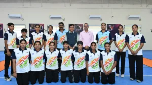 Dr Mansukh Mandaviya with Indian athletes in matching sports jerseys at the SAI NCoE Gandhinagar training centre facility.