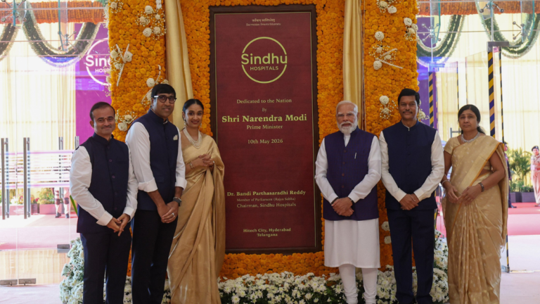 PM Modi and officials stand by a marigold-framed plaque at the Sindhu Hospital inauguration in Hyderabad.