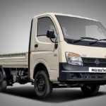 Cream-coloured Tata Ace Gold+ XL mini-truck with an 8-foot cargo bed and a 21-year anniversary seal on a grey background.