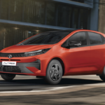 Red Tata Altroz hatchback driving along a city street with modern buildings showcasing its premium design