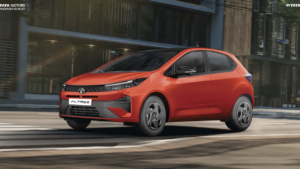 Red Tata Altroz hatchback driving along a city street with modern buildings showcasing its premium design.