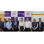 Twelve executives from Tata Motors and HPCL standing with a signed MoU in front of a branded backdrop for the recycling pi...