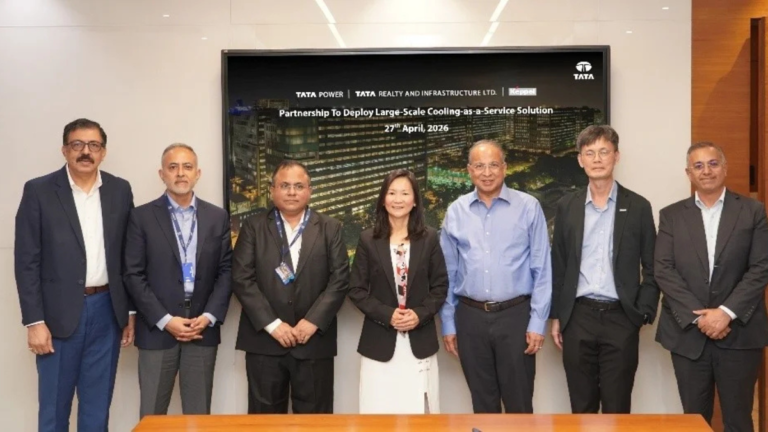 Seven professionals standing before a digital screen announcing Cooling-as-a-Service for Intellion Park in Chennai.