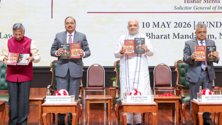 Amit Shah and Tushar Mehta hold two legal humour books at Bharat Mandapam during the New Delhi launch.
