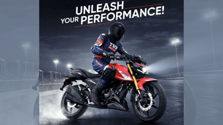 Rider in blue racing suit on a red TVS Apache motorcycle with gold forks on a track during the 2026 India launch.