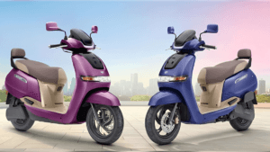 Purple and blue TVS iQube S electric scooters parked side-by-side against a city skyline for the 2026 India launch.