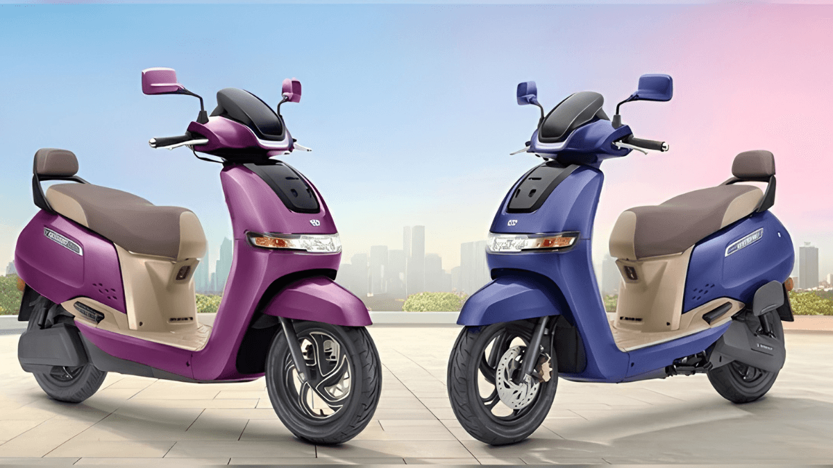 Purple and blue TVS iQube S electric scooters parked side-by-side against a city skyline for the 2026 India launch.
