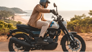 Rider in black jacket on a white TVS Ronin Agonda Edition motorcycle with retro pinstripes on an Indian road.