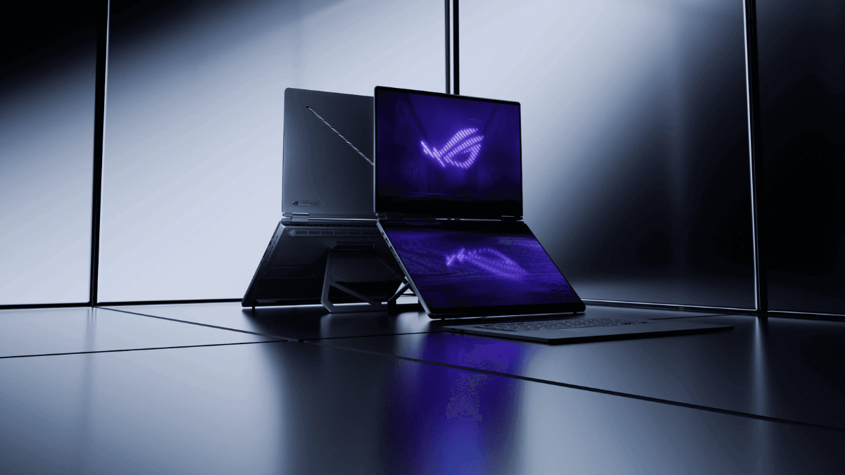 The ultra-thin laptop that makes desktop rigs feel obsolete 1 Two grey ASUS laptops on a dark reflective surface, one showing purple logos on dual OLED screens.