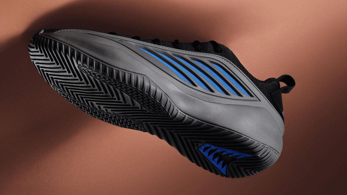 Close-up of the grey and blue sneaker sole showing thick herringbone tread, built for durability on rough Indian courts.