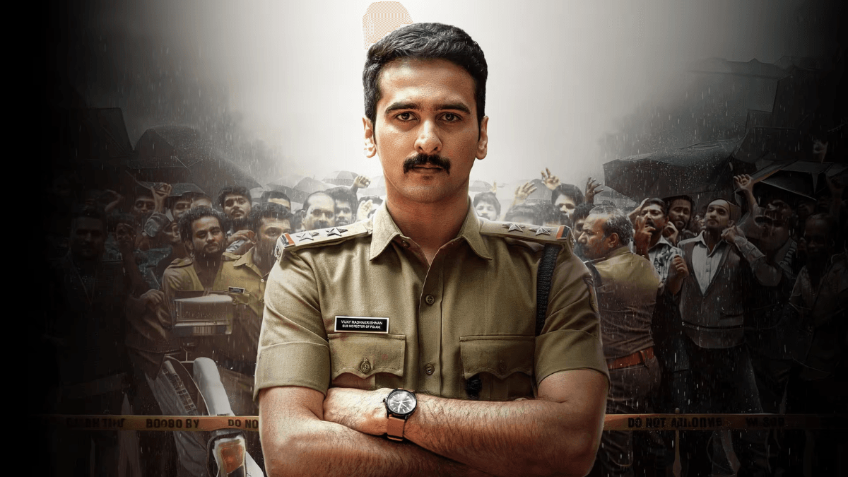 The Malayalam police mystery tailored for a weekend watch 1 Shane Nigam as a police officer with arms crossed, standing before a crowded village scene in Malayalam movie Dridam.