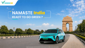Cyan-green VinFast electric car on an empty road in front of India Gate under a blue sky in Delhi.