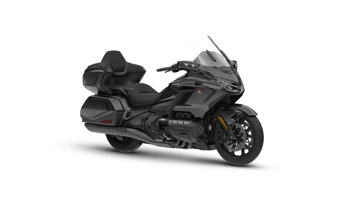 Does a motorcycle really need an airbag and an automatic box? 2 Three-quarter view of a Gun Metal Black Honda Gold Wing grand tourer with a clear windscreen on a white background.