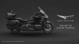 Side profile of a Gun Metal Black Honda Gold Wing cruiser on a dark background with promotional luxury touring text.