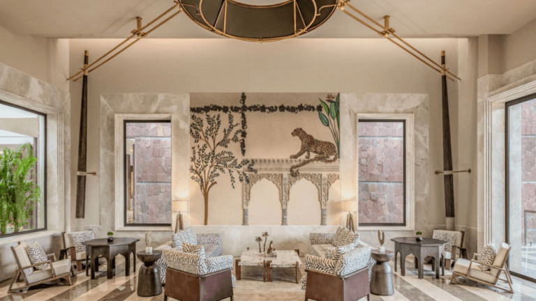 A luxury Rajasthan getaway built for family safaris 5 A luxury resort lobby with animal print chairs, marble flooring, and a large wall mural depicting a leopard in Rajasthan.
