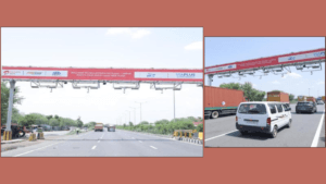 Overhead toll gantry with cameras above a white van and truck at the Daulatpura free-flow plaza on NH-48.