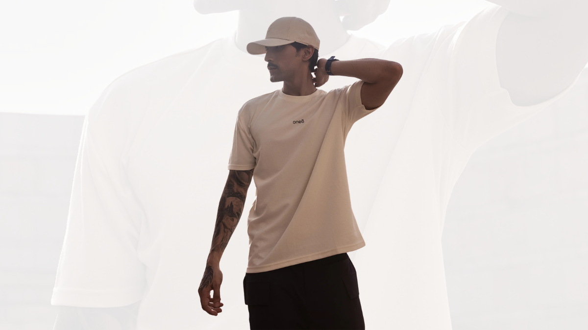 The cricket captain leaves a ₹300 crore deal to go solo 2 A tattooed man wearing a beige t-shirt and cap looking sideways against a bright backlit background, apparel line.