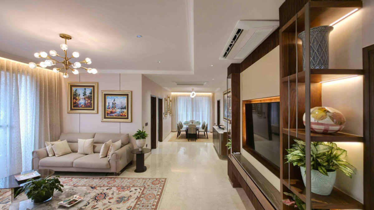 Does an AI climate system genuinely fix Delhi air quality? 2 Ceiling cassette AC unit in an open living room with a beige sofa, patterned rug, and wood TV console in India.
