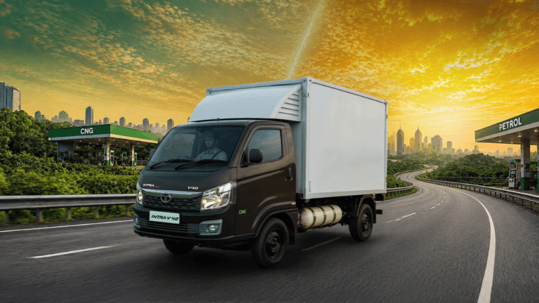 A 1,525 kg payload pickup running on both CNG and petrol 1 Tata Intra V40 bi-fuel truck with enclosed cargo driving on a highway between CNG and petrol stations in India.