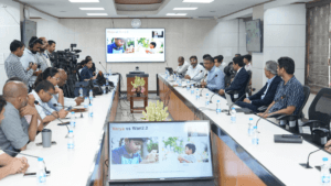 Officials in a press room looking at screens displaying a Varya AI video generation comparison slide in India.