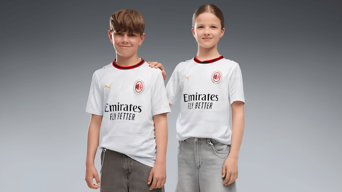 The shirt Inzaghi wore in spirit built for extreme heat 2 Two children wearing white AC Milan youth away replica jerseys standing against a solid studio background setting.