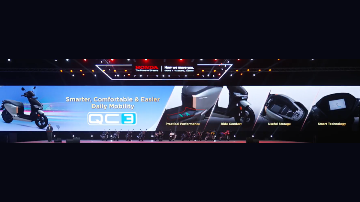 A 151 km range and E85 fuel reframe daily scooter choices 1 A digital stage presentation shows the silver Honda QC3 electric scooter displaying its storage and screen in India.