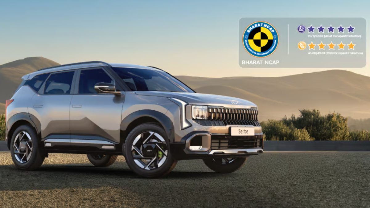 Silver SUV on gravel ground with distant hills under a blue sky next to a Bharat NCAP safety rating graphic Seltos.