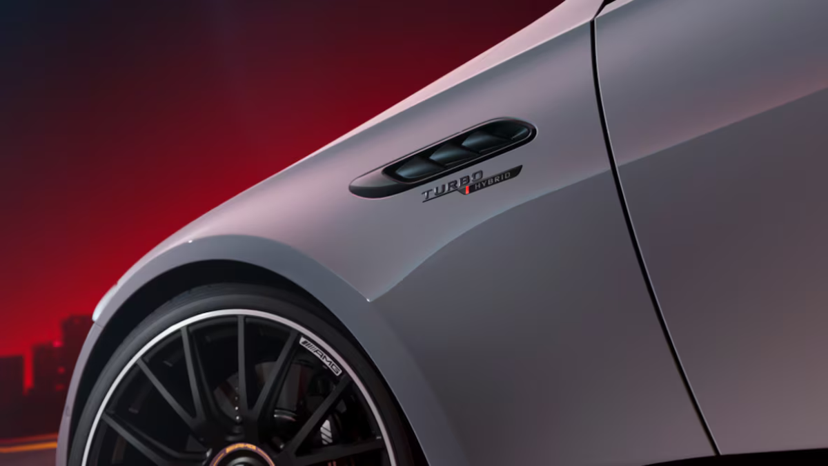Close-up of front fender vent with Turbo Hybrid badging and AMG alloy wheel on a light grey car body.